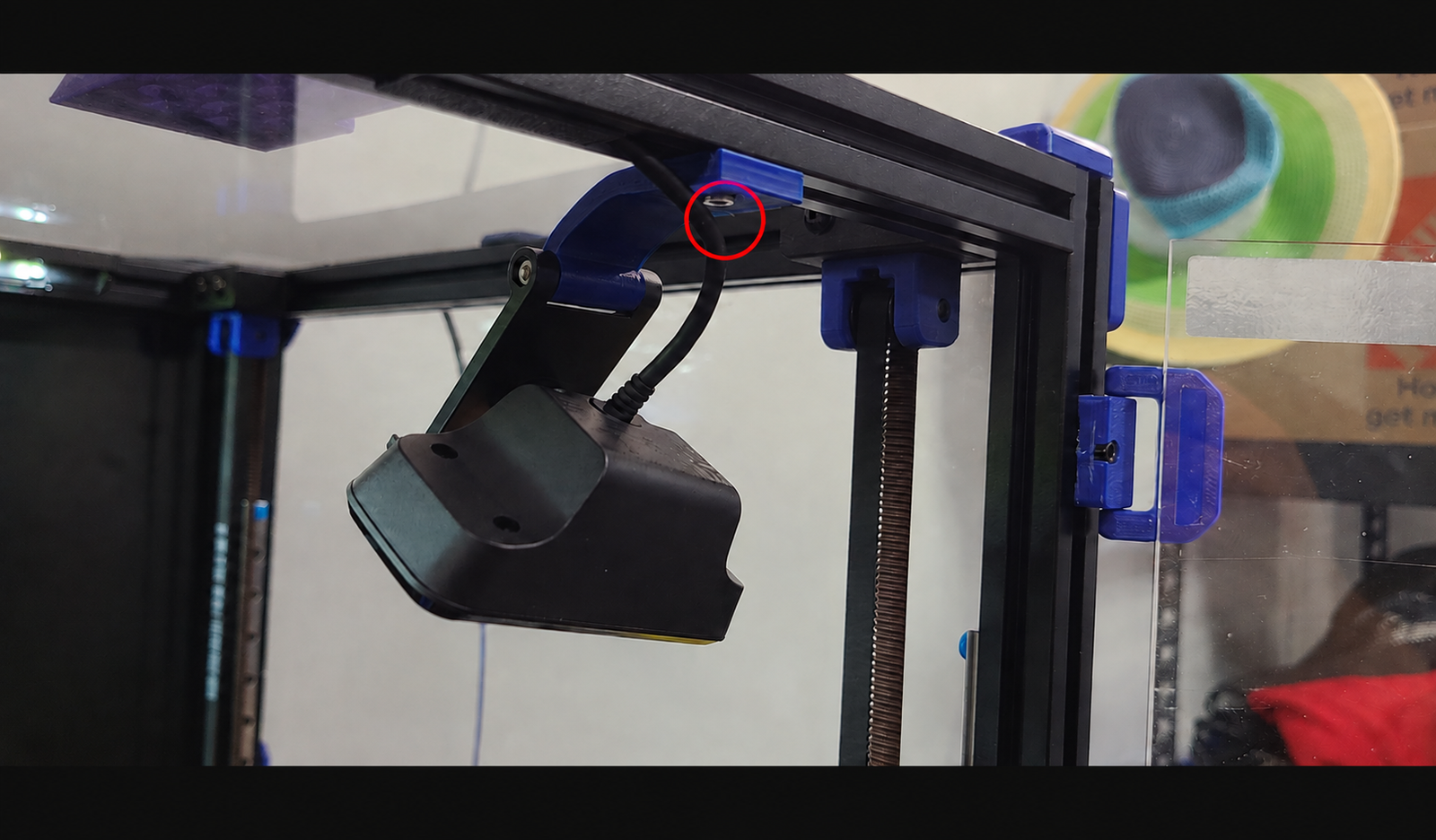 Support de caméra imprimé en 3D : vis de fixation sous le support bleu entourée en rouge